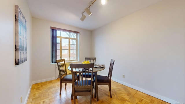 dining space with track lighting and baseboards