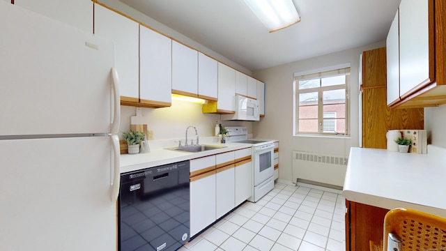 kitchen with light countertops, white appliances, radiator heating unit, and a sink