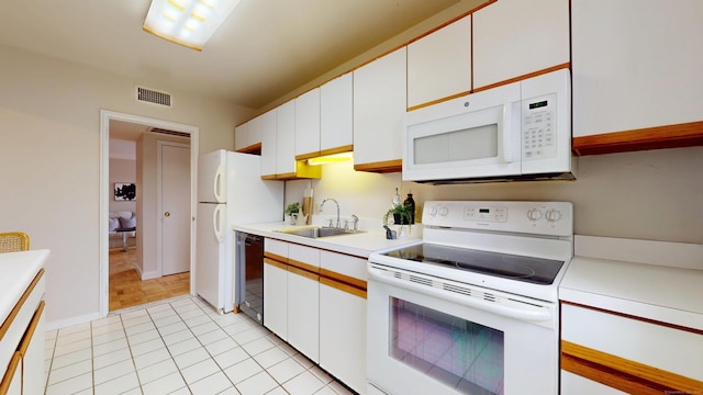 kitchen with white appliances, visible vents, light countertops, white cabinetry, and a sink