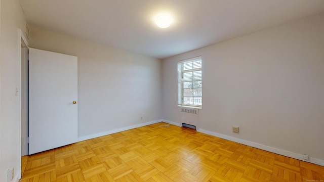 empty room with radiator heating unit and baseboards