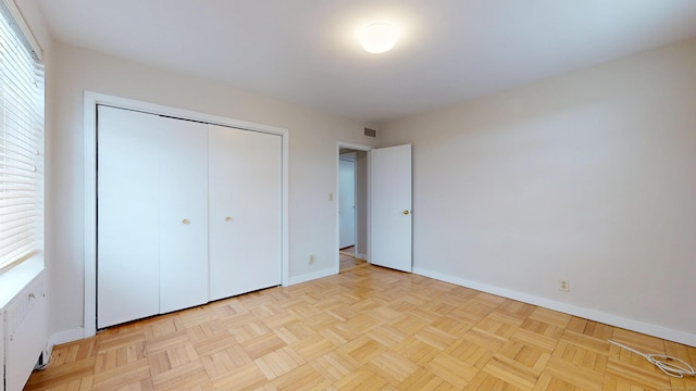 unfurnished bedroom with baseboards, visible vents, and a closet