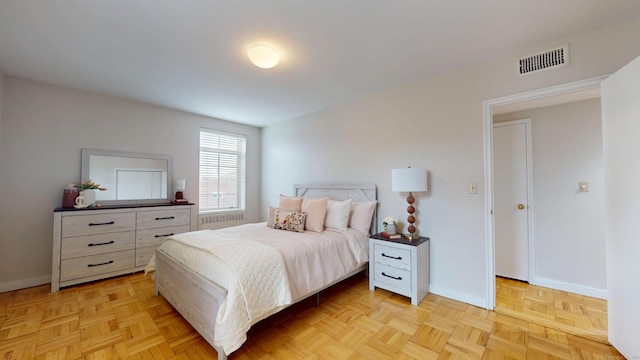 bedroom featuring baseboards, visible vents, and radiator heating unit