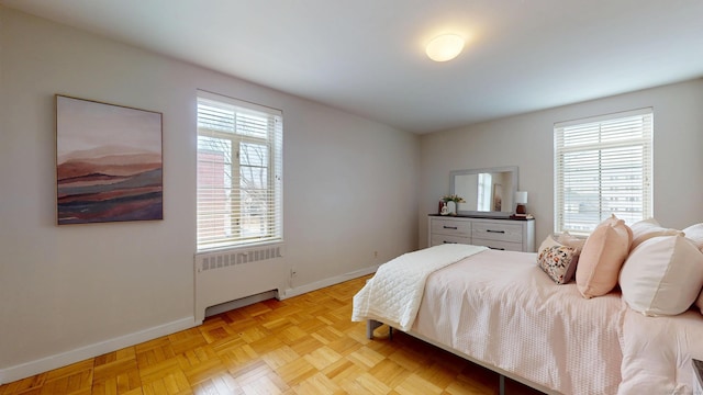 bedroom featuring baseboards and radiator