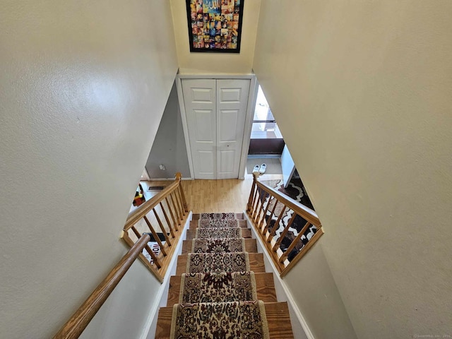 stairs featuring wood finished floors and baseboards