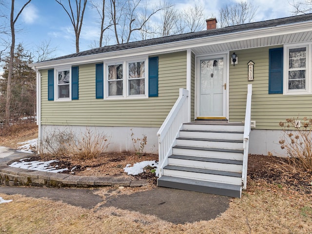 view of front of property with entry steps and a chimney