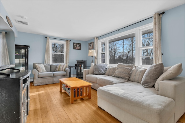 living room featuring visible vents and light wood-style flooring