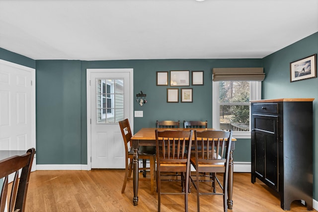 dining area with light wood-type flooring and baseboards