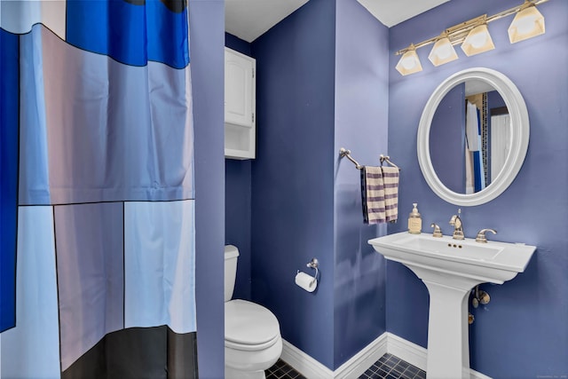 bathroom featuring baseboards, toilet, and tile patterned floors