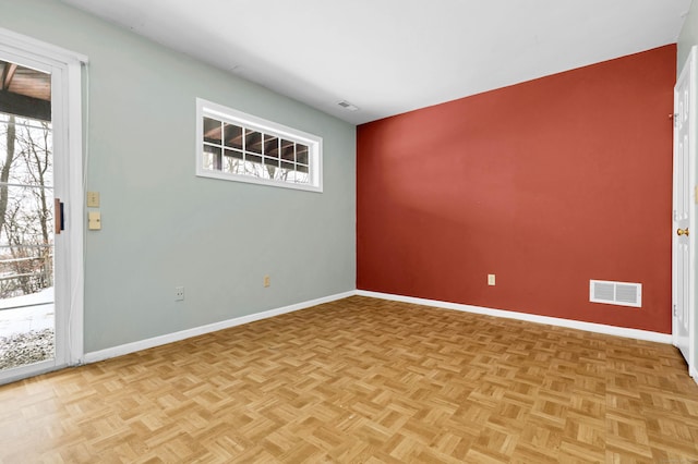 unfurnished room with baseboards and visible vents