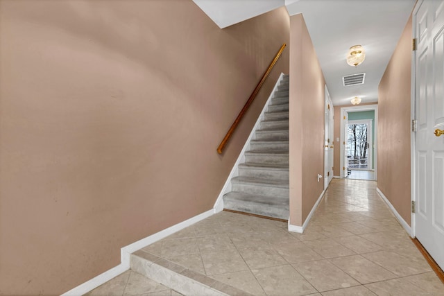 staircase with visible vents, baseboards, and tile patterned floors