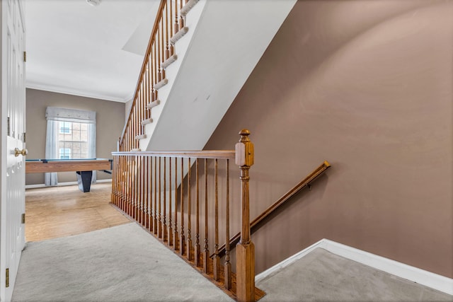 stairway featuring ornamental molding, carpet, and baseboards