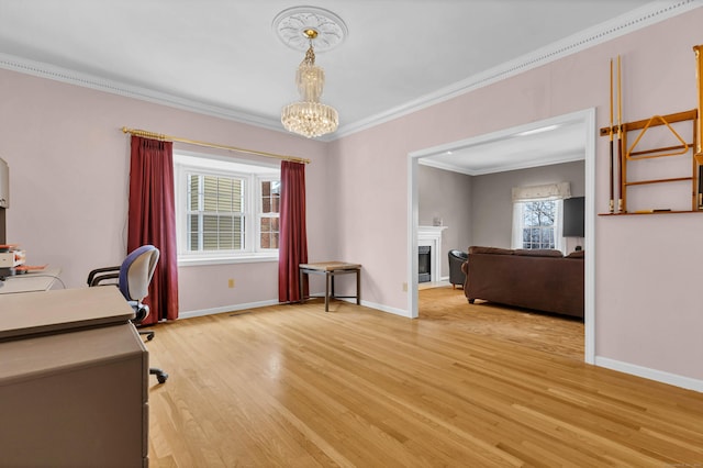 unfurnished office with baseboards, light wood-type flooring, a fireplace, and crown molding