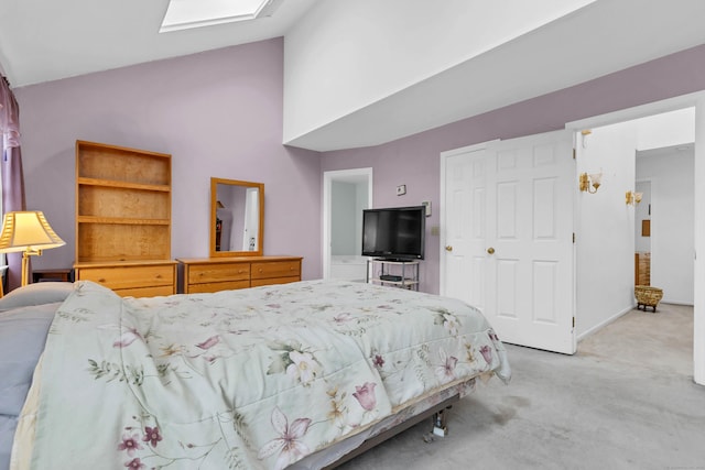 bedroom featuring carpet, vaulted ceiling with skylight, and a closet