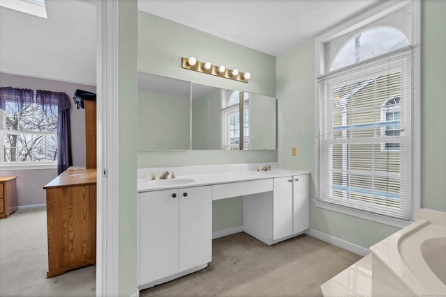 full bath with a bathtub, vanity, and baseboards