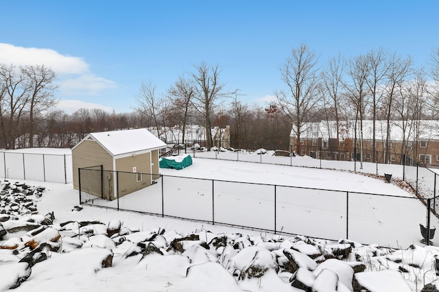 yard covered in snow with a garage, fence, and an outdoor structure