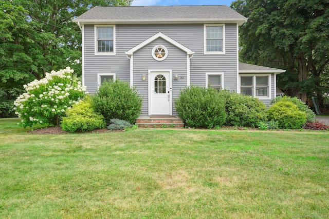 colonial house with a shingled roof and a front lawn