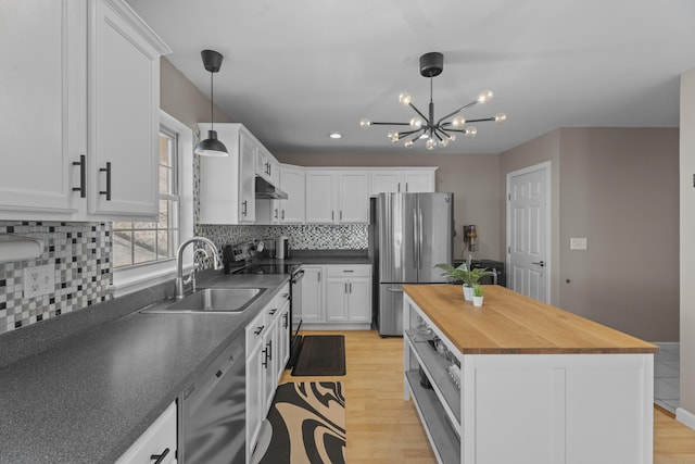 kitchen featuring decorative light fixtures, white cabinetry, a kitchen island, a sink, and black appliances