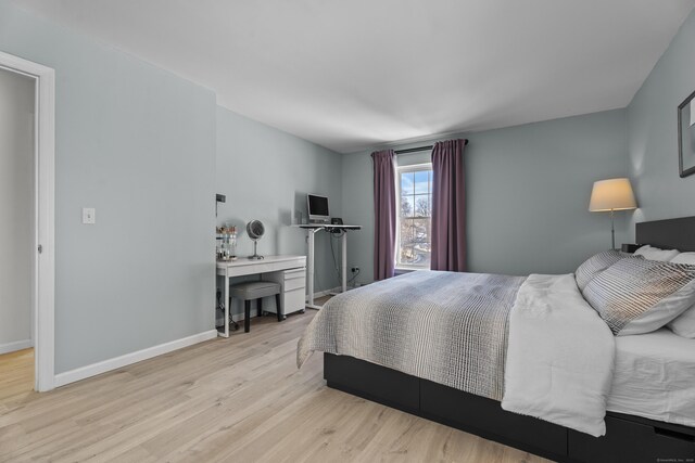 bedroom with light wood-type flooring and baseboards