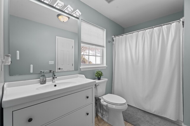 bathroom featuring visible vents, a shower with shower curtain, vanity, and toilet