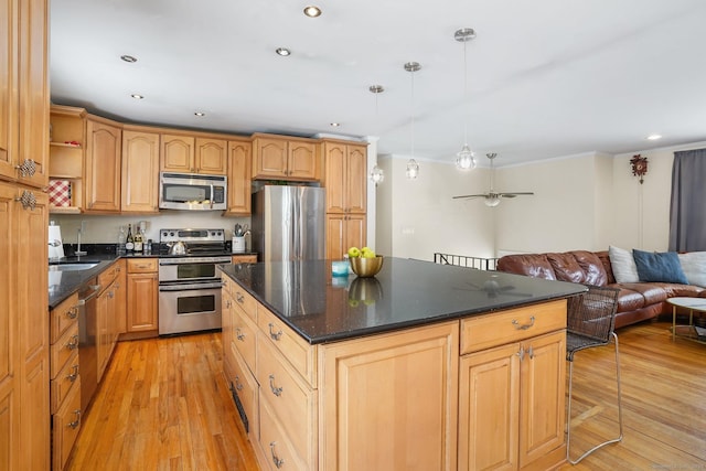 kitchen featuring dark countertops, stainless steel appliances, hanging light fixtures, and open floor plan