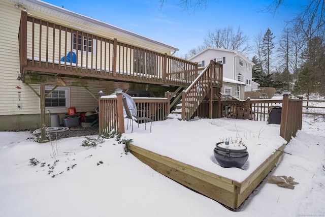 snow covered property with a deck and stairway