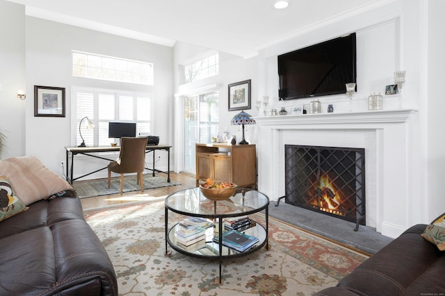 living area featuring a warm lit fireplace, wood finished floors, and baseboards