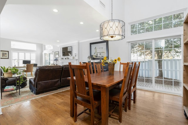 dining area featuring recessed lighting, visible vents, a high ceiling, and light wood finished floors