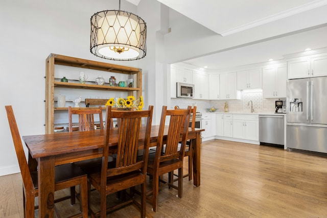 dining room with ornamental molding and light wood finished floors