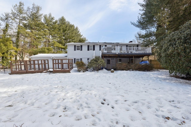 snow covered rear of property featuring a wooden deck