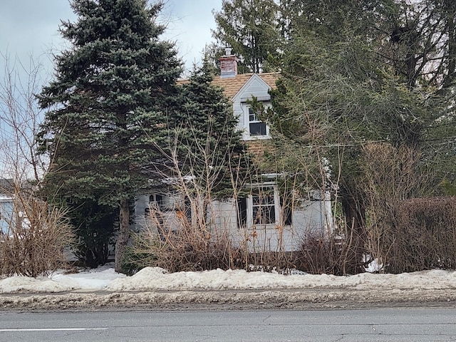 view of snow covered exterior with a chimney