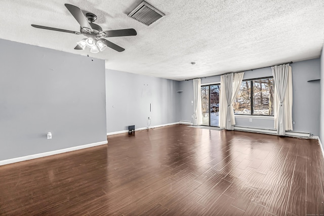 spare room with baseboards, a textured ceiling, visible vents, and wood finished floors