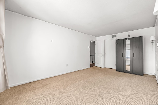 unfurnished bedroom with carpet, visible vents, and baseboards