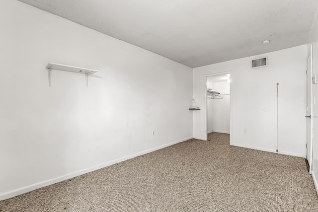 unfurnished bedroom with carpet floors, attic access, visible vents, and baseboards