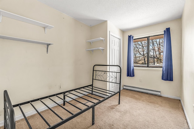 carpeted bedroom with a baseboard heating unit, a closet, a textured ceiling, and baseboards