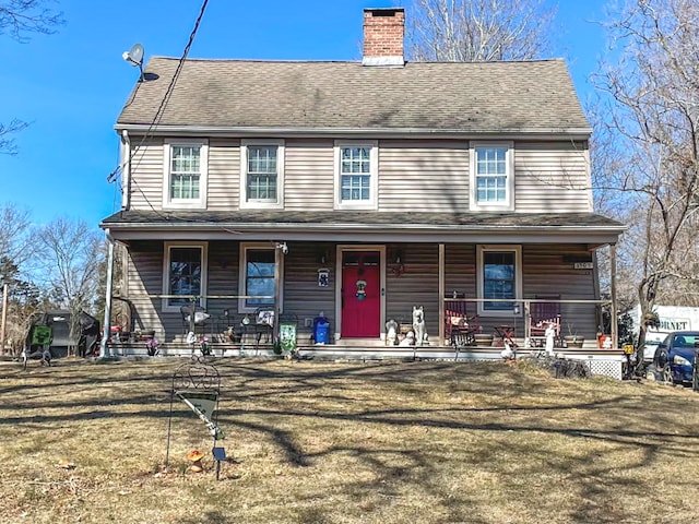 view of front of house featuring covered porch, a chimney, a front lawn, and roof with shingles