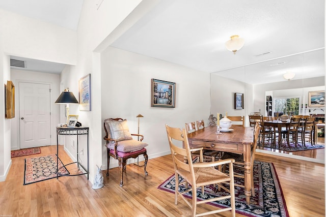 dining room with visible vents, light wood-style flooring, and baseboards