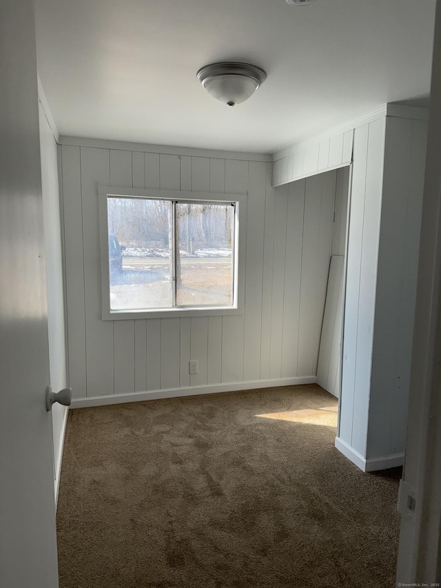 empty room with baseboards and dark carpet