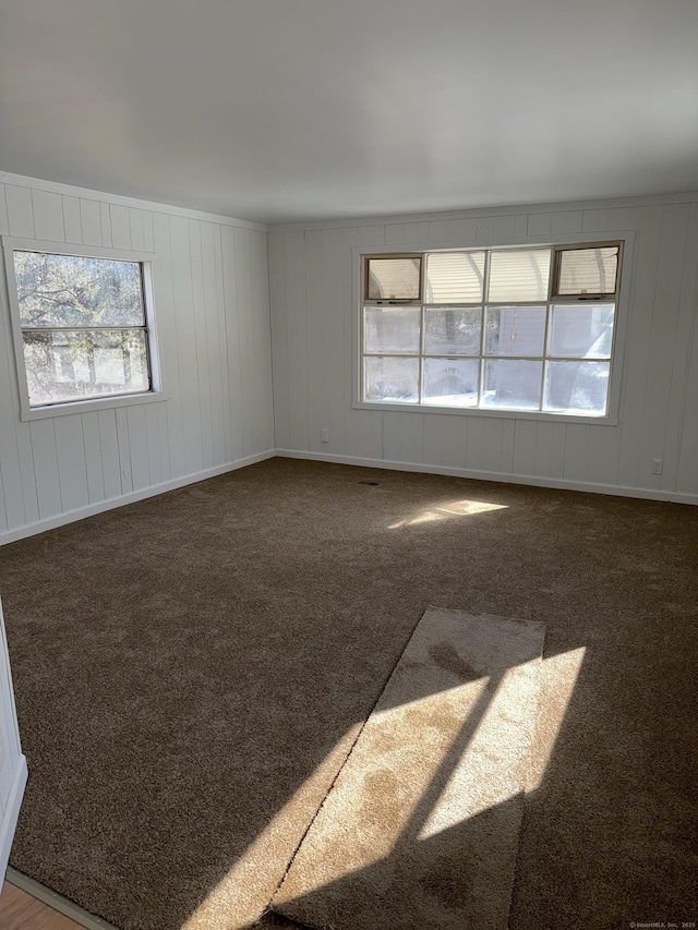 empty room with dark carpet and baseboards