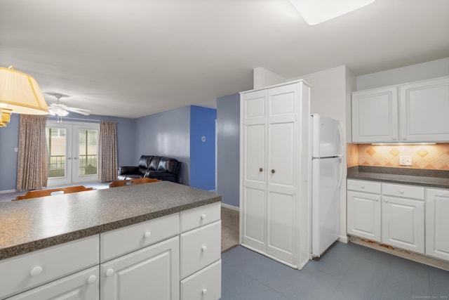 kitchen featuring white cabinets, dark countertops, open floor plan, freestanding refrigerator, and french doors