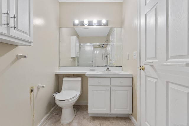 bathroom featuring toilet, a stall shower, vanity, and baseboards