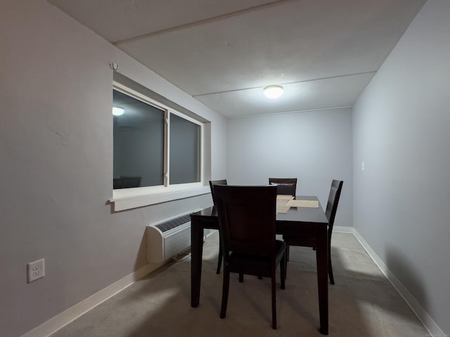 carpeted dining space with a wall mounted air conditioner and baseboards