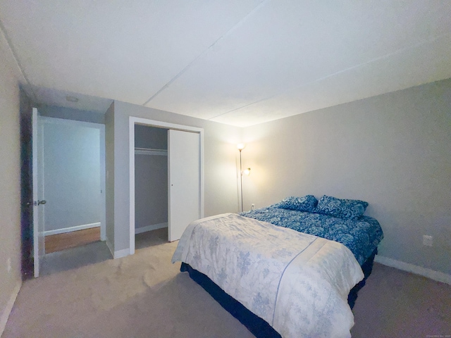 carpeted bedroom with baseboards and a closet