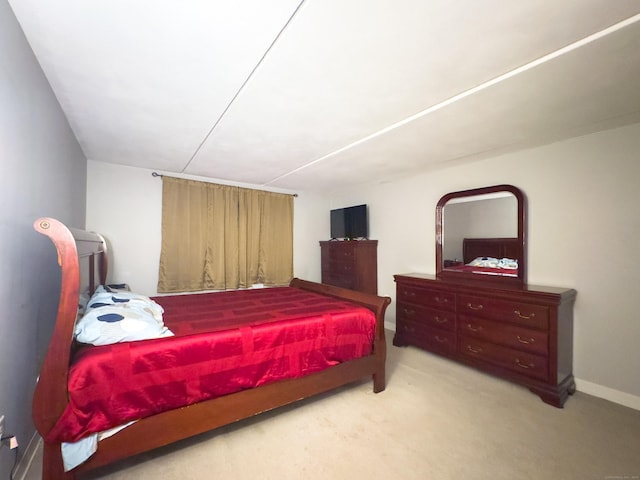 bedroom with baseboards and light colored carpet