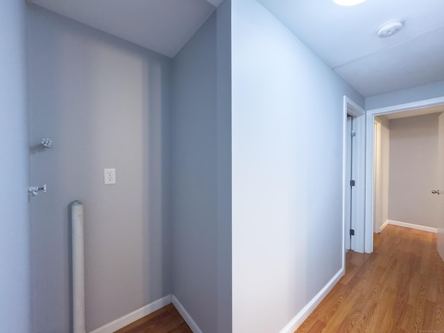 hallway featuring light wood-style floors and baseboards