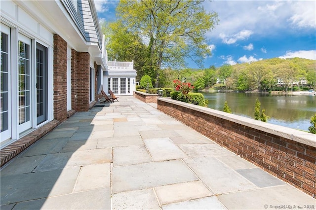 view of patio featuring french doors and a water view