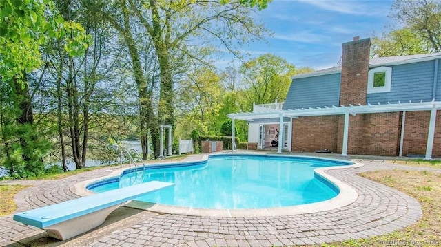 outdoor pool featuring a diving board and a pergola