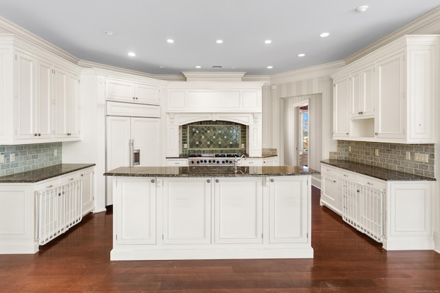 kitchen featuring a center island with sink, dark wood finished floors, range, and dark stone countertops