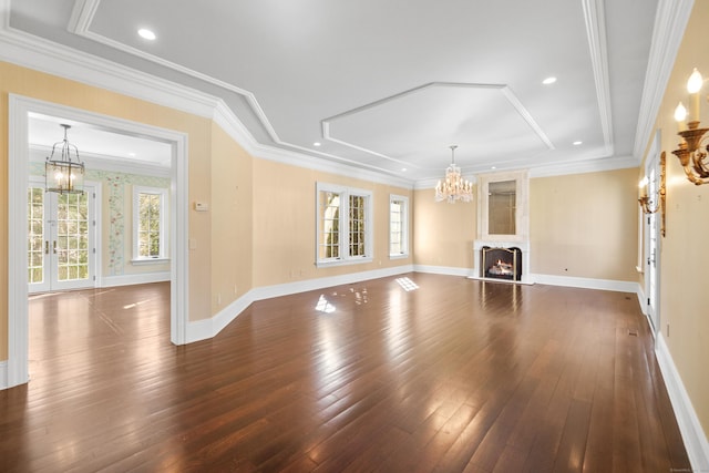 unfurnished living room featuring a chandelier, a large fireplace, dark wood finished floors, and crown molding