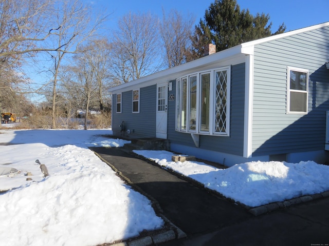 324 Maple St, Branford, CT 06405 - view of snowy exterior featuring a chimney
