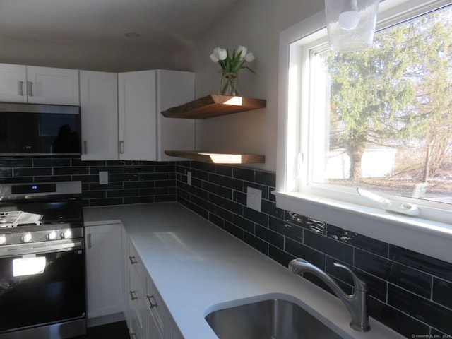 324 Maple St, Branford, CT 06405 - kitchen featuring white cabinets, stainless steel appliances, light countertops, a sink, and decorative backsplash
